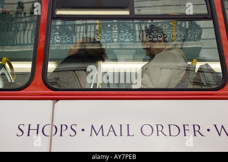 Persone che dormono sul London bus Foto Stock