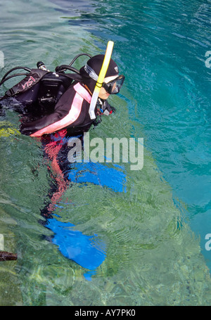 Una ragazza adolescente fa un controllo di sicurezza della sua attrezzatura subacquea, durante la scuola sub presso il Blue Hole in Santa Rosa, Nuovo Messico. Foto Stock