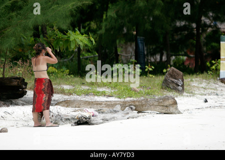 Giovane donna in sarong prende foto della spiaggia di Pattaya Ko Lipe isola della Thailandia Foto Stock