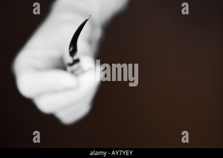 Mano con guanto chirurgico bisturi di contenimento Foto Stock