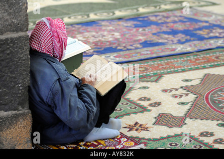 Un uomo musulmano la lettura del Corano in una moschea, in Bosra, Siria. Foto Stock