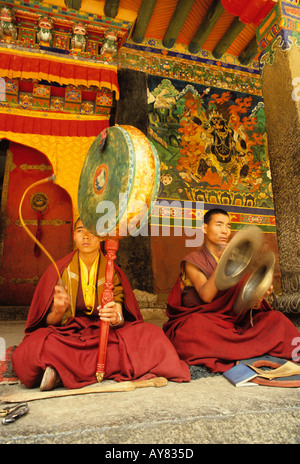 Musicista monaci nel monastero tibetano tradizionale riproduzione di corna e tamburi Foto Stock