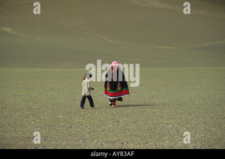 Donna nomade in un tradizionale manto di feltro e il bambino a metà il Tibet vicino a Tingri Foto Stock