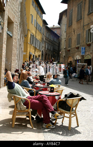 Per coloro che godono di sole in una street cafe a Urbino le Marche, Italia Foto Stock