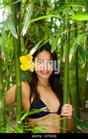 Giovane e bella donna polinesiana in una foresta di bamboo Foto Stock