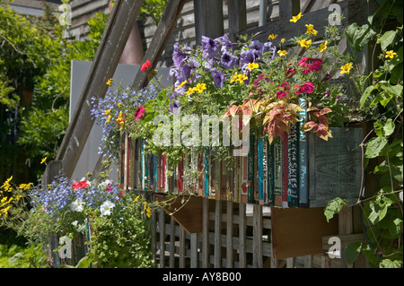 Fiori d'estate in fioriere decorate con libro spine nei pressi di ingresso posteriore di book store Langley Whidbey Island Washington Foto Stock