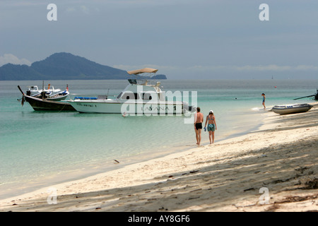 Giovane passeggiare lungo la spiaggia di sabbia bianca di Ko Kradan isola della Thailandia Foto Stock