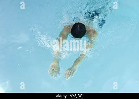 Uomo di nuoto in piscina, a testa in giù, braccia tese davanti a lui Foto Stock