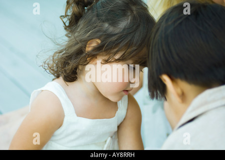 Due bambini faccia a faccia, guardando in basso vista ritagliata Foto Stock