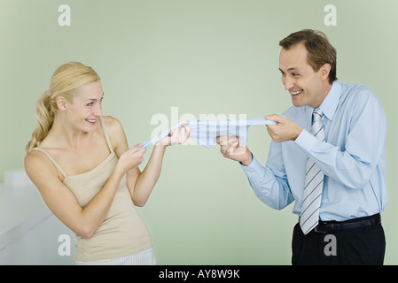 Matura in lotta per i vestiti del bambino, sorridente ad ogni altro Foto Stock