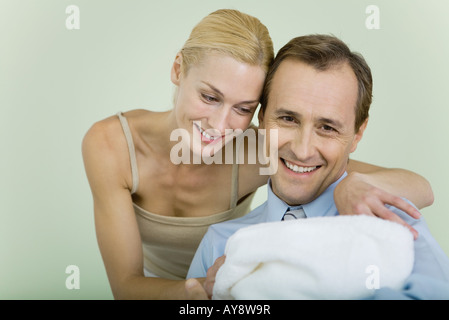 Giovane Azienda nuovo bambino avvolto in una coperta, sorridente, uomo guardando la fotocamera Foto Stock