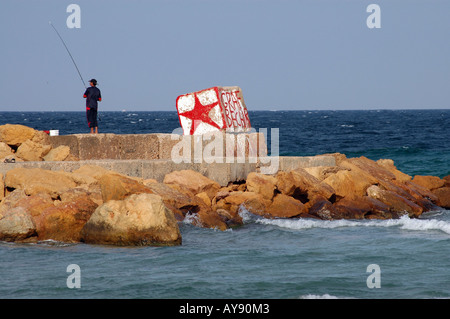 Ragazzo tunisino la pesca su una roccia nella città di Sousse, Mare mediterraneo, Tunisia Foto Stock