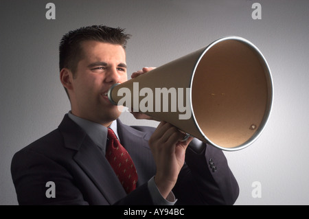 Giovane uomo d affari urla attraverso un megafono Foto Stock