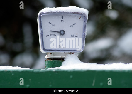 Indicatore di livello carburante ricoperta di neve e mostrando quasi vuota sul riscaldamento domestico serbatoio olio Foto Stock