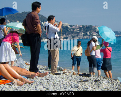 Un gruppo di nuovi arrivati i turisti frolic sulla spiaggia di Nizza, sulla Cote d'Azur, Costa Azzurra, Francia Foto Stock