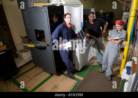 I lavoratori di essere addestrati all'uso di un pezzo di macchine con i comandi di calcolatore Foto Stock