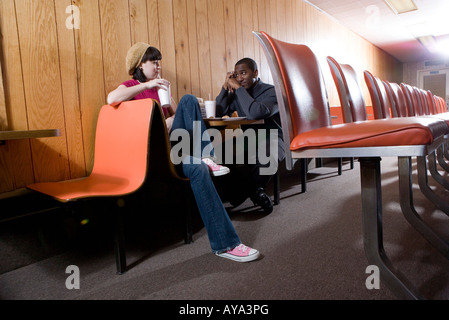 Allegro giovani inter-razziale giovane seduto in un diner Foto Stock