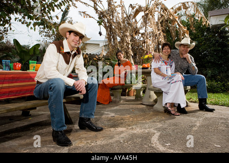 Ritratto di un allegro Tex-Mex famiglia seduti insieme nel cortile di casa Foto Stock