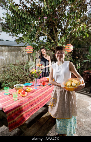 Mexican-American madre e figlia e impostazione di un tavolo da picnic Foto Stock