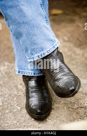 Close-up di un uomo in piedi in blue jeans e stivali da cowboy Foto Stock