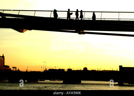 I pedoni a piedi attraverso il Millenium Bridge di Londra. Foto Stock