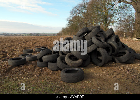 Ribaltamento illegale di pneumatici per veicoli scaricati in un campo agricolo per evitare di pagare le spese di smaltimento, grande problema di ribaltamento in campagna Essex Inghilterra Regno Unito Foto Stock