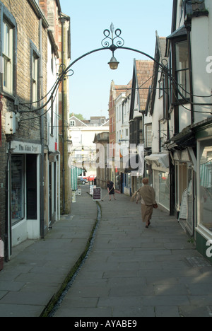 Da Cheap Street con un canale d'acqua che scorre lungo il marciapiede in uno stretto canale sotterraneo aperto con negozi su entrambi i lati Somerset Inghilterra Regno Unito Foto Stock