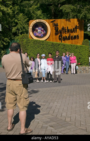 Famiglia pone per foto nella parte anteriore del segno ai Giardini Butchart in Victoria British Columbia Foto Stock
