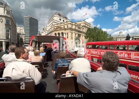 Londra Trafalgar Square a bordo di open top tour bus turistico di passeggeri con autobus normale passante pubblicità Harrods Vendita Foto Stock