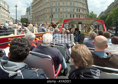 Londra Trafalgar Square di passeggeri a bordo di open top tour bus panoramico a fianco di un pranzo concorrenti società bus veicolo Foto Stock