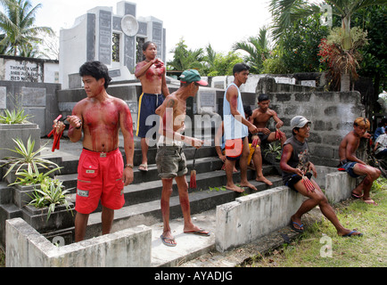 Filippino flaggelants hit themselve il Venerdì Santo al cimitero nel Gasan, Marinduque Isola, Filippine Foto Stock