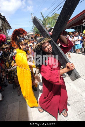 Filippine, la processione di Pasqua a Moriones Festival il Venerdì Santo. Cuscinetto a Gesù la croce nel cammino della croce processione Foto Stock