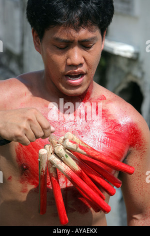 Filippino flaggelants hit themselve il Venerdì Santo al cimitero nel Gasan, Marinduque Isola, Filippine Foto Stock