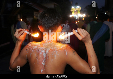 Flagellant alla processione del Venerdì santo, un uomo di tormenti se stesso a caldo con cera di candela. Isola di Marinduque, Filippine Foto Stock