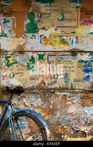 Bike appoggiata contro strappato poster su una parete a Negombo, nei pressi di Colombo, Sri Lanka. Foto Stock