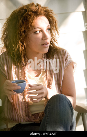 Close-up di una giovane donna che mantiene una tazza di espresso Foto Stock