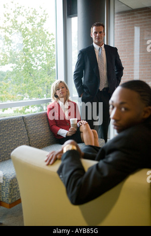 Vista in elevazione del business persone sedute e in attesa in un ufficio area lounge Foto Stock
