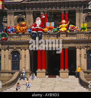 Il Municipio facciata decorato per il Natale con enormi aria gonfiata compresi i giocattoli di Babbo Natale sventolando in Sydney Australia Foto Stock