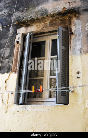 Una finestra con metà persiane aperte da una casa di età Foto Stock