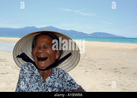 Un'anziana donna vietnamita ridendo mostrando il suo betel denti macchiati da una vita di masticare il cancro di betel il dado. Cua Da Foto Stock