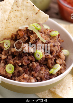 Close up di una ciotola di refried fagioli con tacos Foto Stock