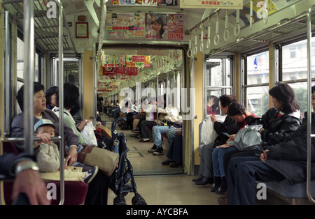 Pendolari su un treno della metropolitana di Tokyo Foto Stock