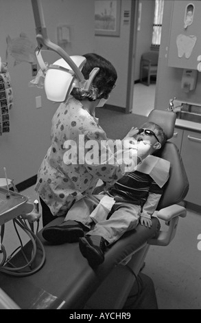 Piccolo Ragazzo di ottenere denti puliti in un studio dentistico Foto Stock