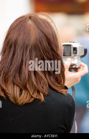 Parte posteriore closeup colpo alla testa vista di un turista scattare fotografie nel centro della città di Dundee, Regno Unito Foto Stock