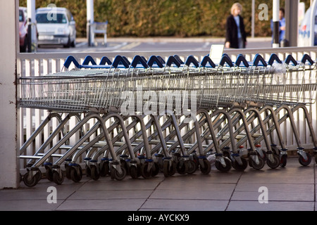 Carrelli allineate in una fila in riva al fiume e il supermercato Tesco a Dundee, Regno Unito Foto Stock