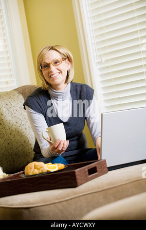 Donna al lavoro su computer portatile da casa Foto Stock