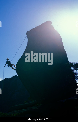 Bouldering su una grande roccia contro il sole Foto Stock