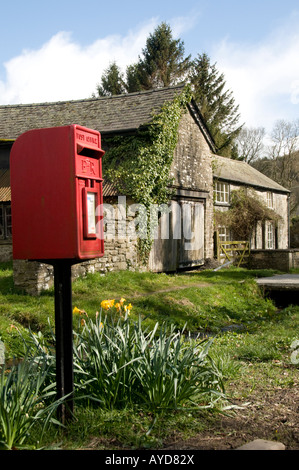 Letterbox rosso e la vecchia casa in acqua Street New Radnor village Powys Galles centrale un flusso corre giù road di fronte agli edifici Foto Stock