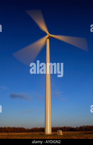 Unico grande filatura turbina eolica sfocati producono energia elettrica contro un cielo blu al tramonto Ontario Foto Stock