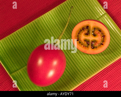 La frutta esotica Tamarillo Solanum betaceum o albero pomodoro su una piastra verde Foto Stock